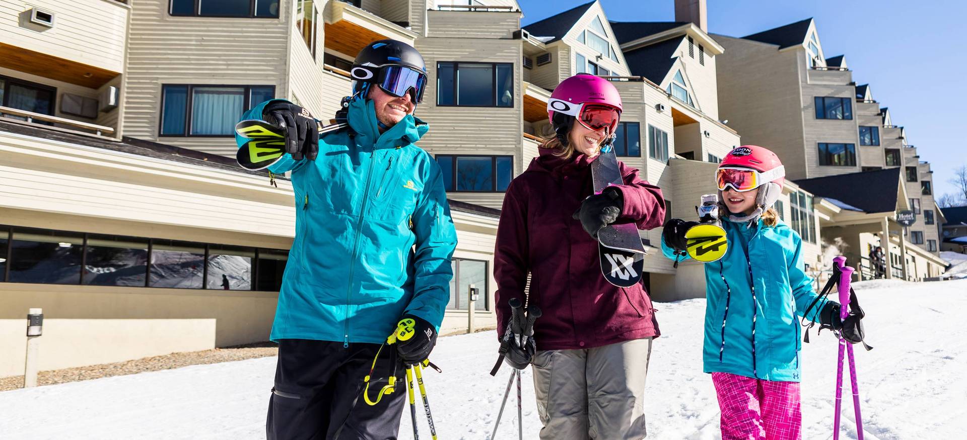 Family carrying their ski equipment, walking slopeside at Loon Mountain