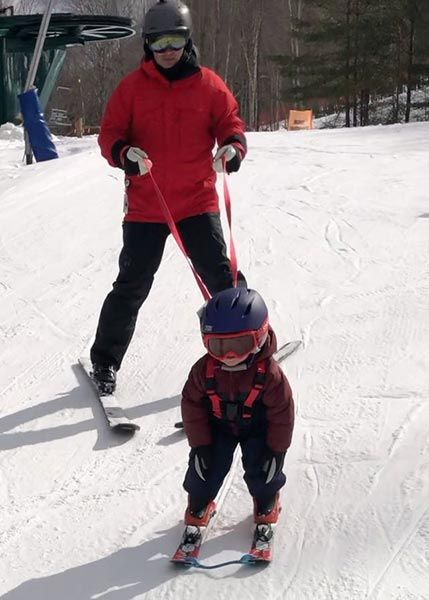 dad with young kid on ski leash