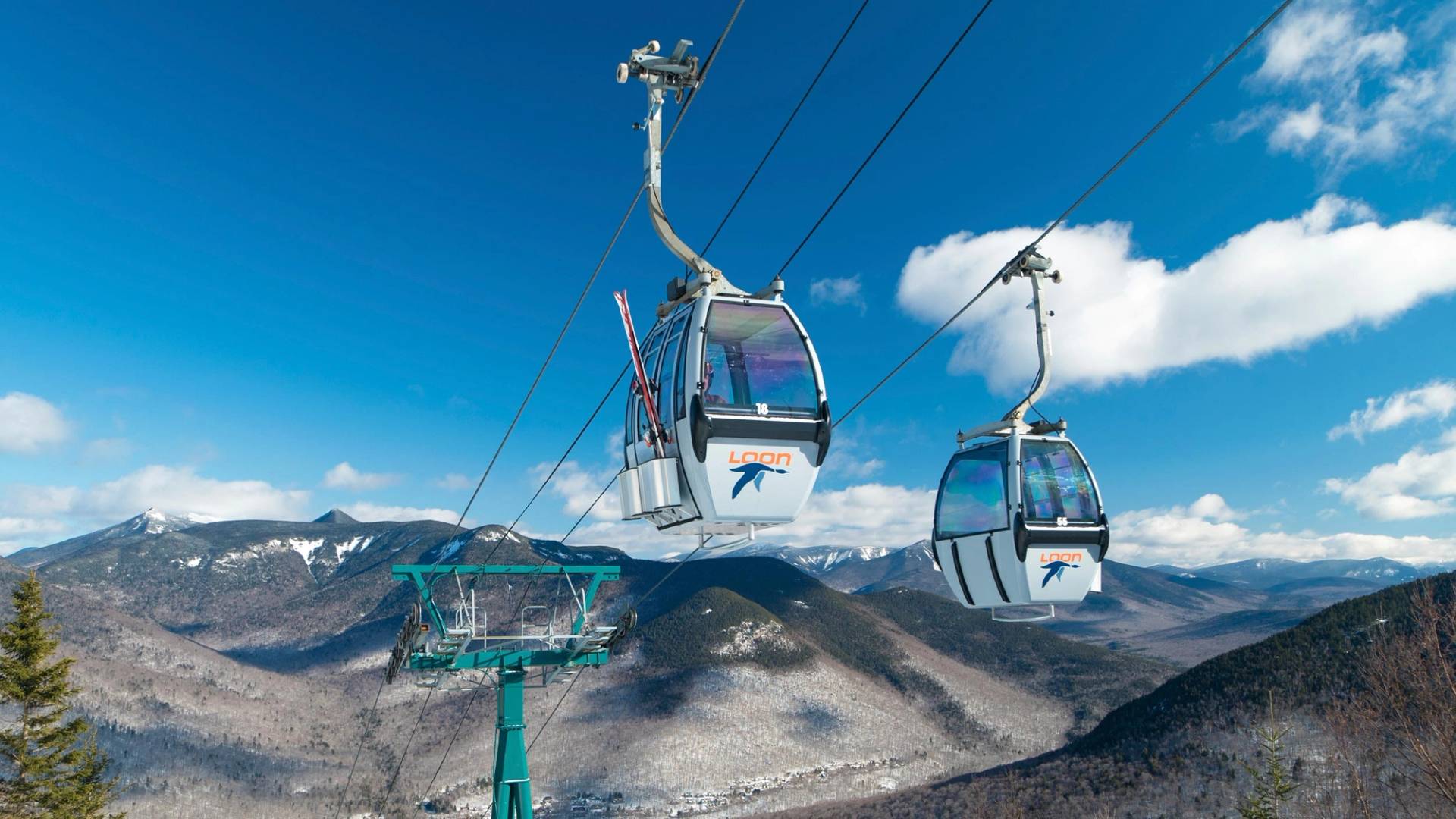 winter gondola with mountain peaks in background