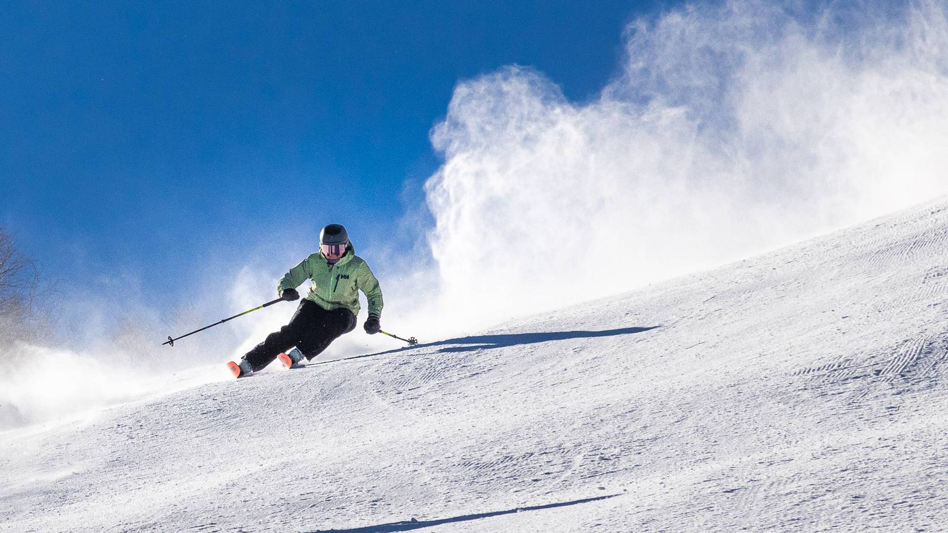 skier in green jacket on a sunny day