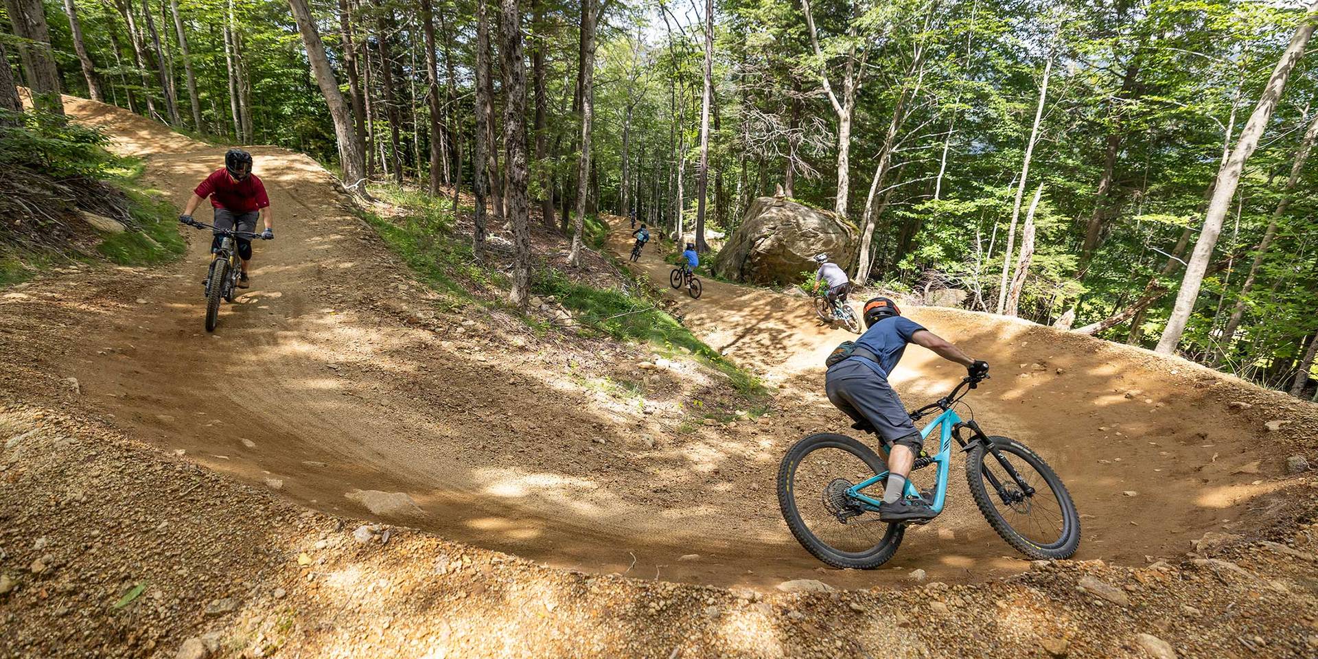Group of downhill bikers riding a berm in Loon Bike Park