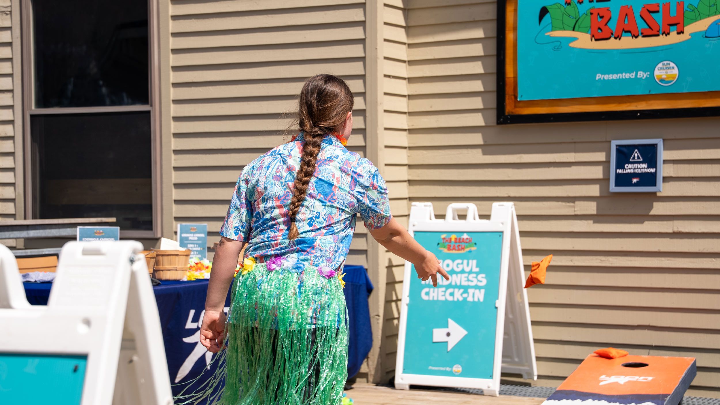girl playing corn hole at the beach bash