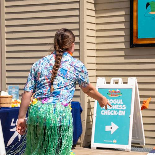 girl playing corn hole at the beach bash