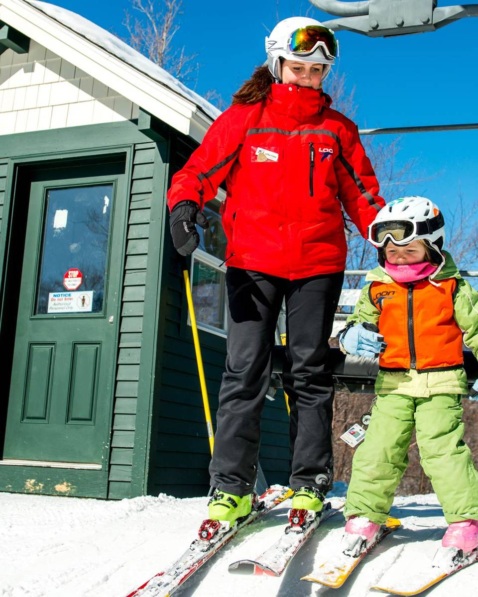 child and adult getting off lift