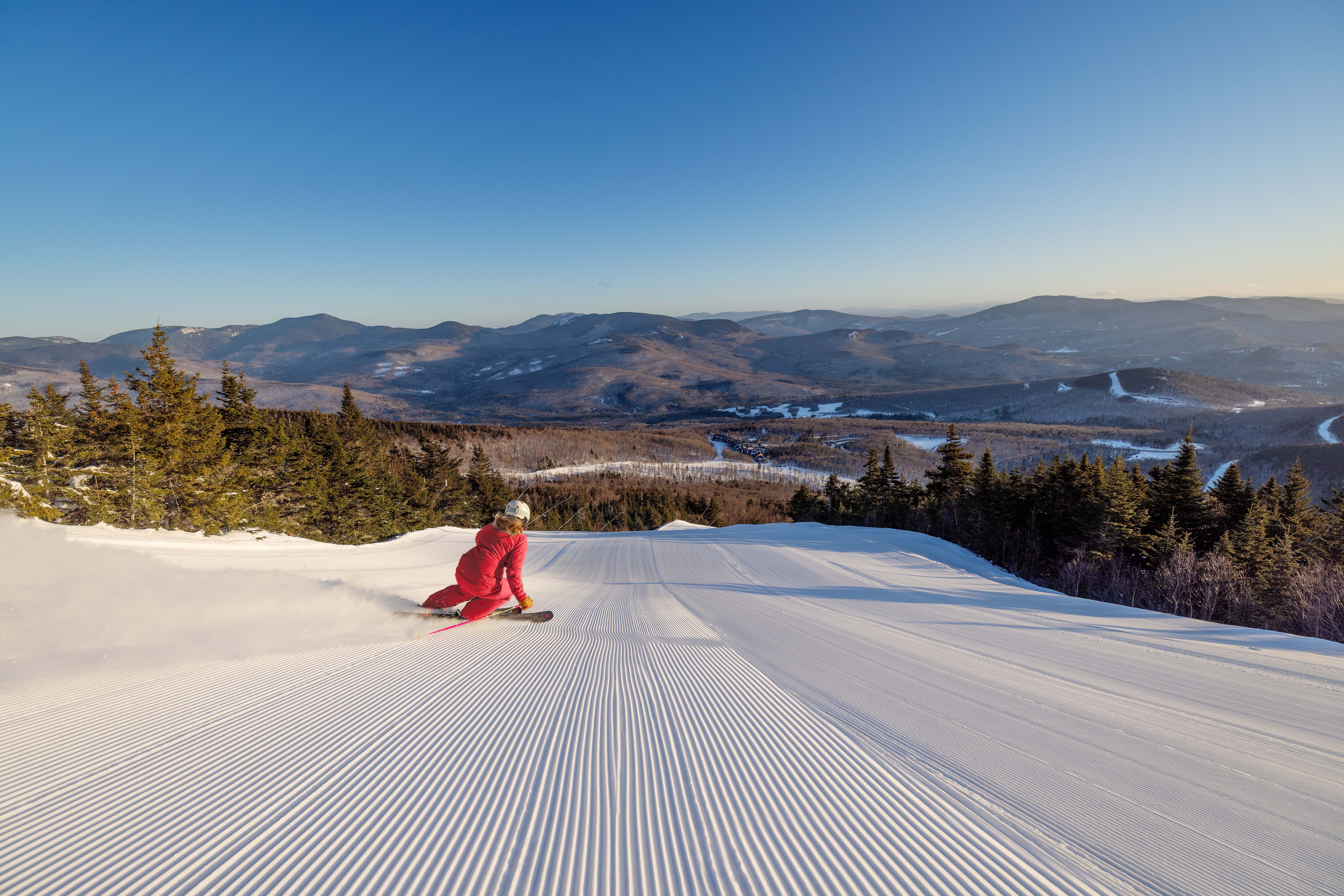 Skier in red jacket skiing away from the camera