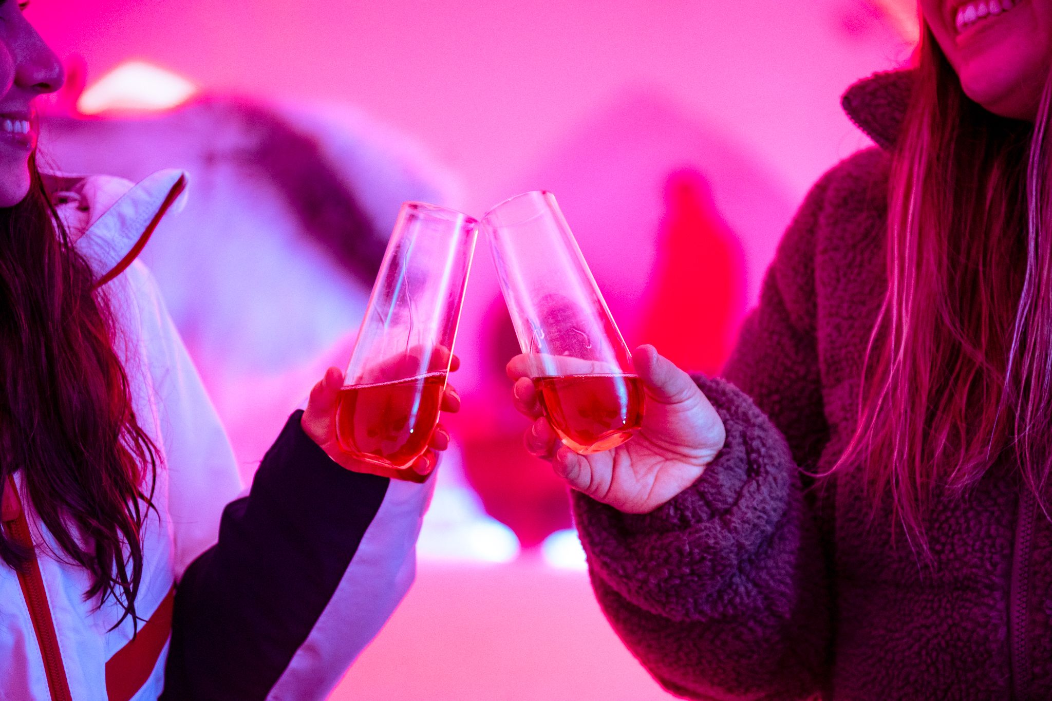 People toasting with champagne in an iglu.