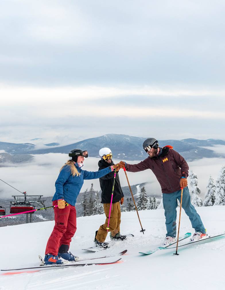 People fist bumping on skis.