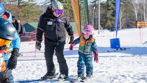 Little girl gets help from her instructor