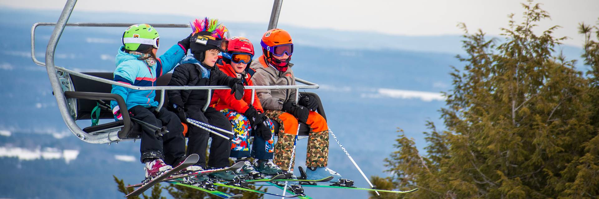 Four colorful kids on the chairlift