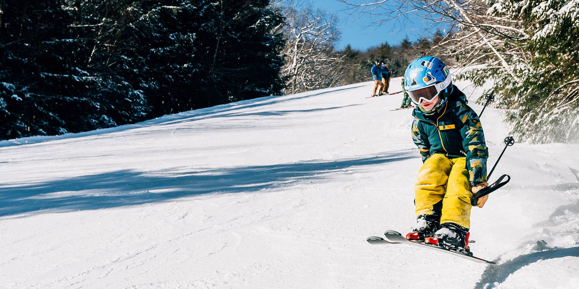 Kids jumping over a snowy kicker