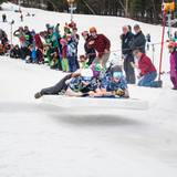 Racers sail across the finish line on a full-sized mattress.