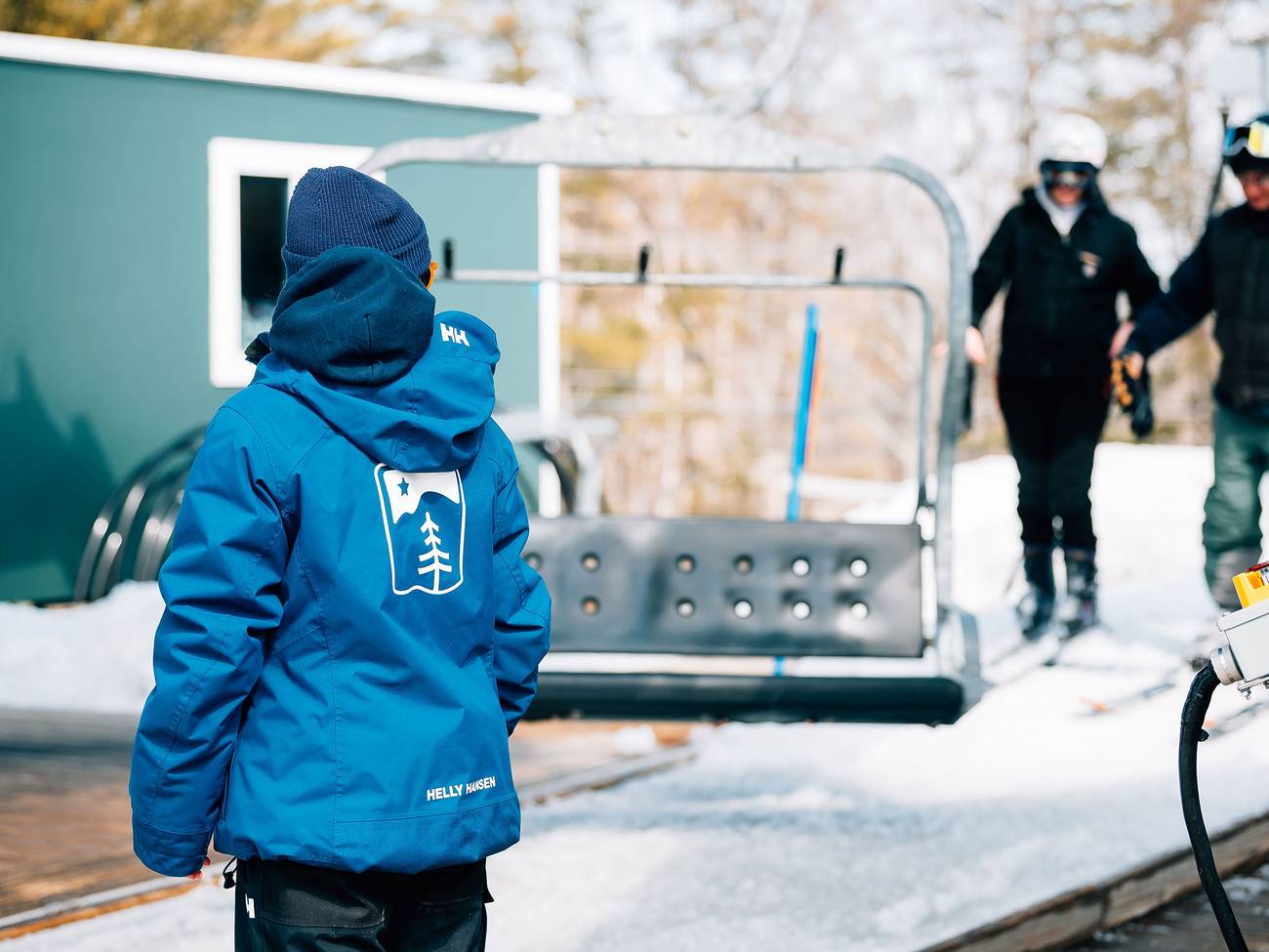 Lift operator watches guests loading chair lift