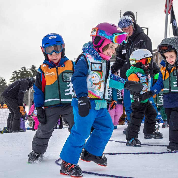 Childrens learning skills without their skis on the snow