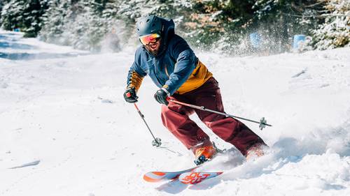 Male smiling and charging through fresh snow