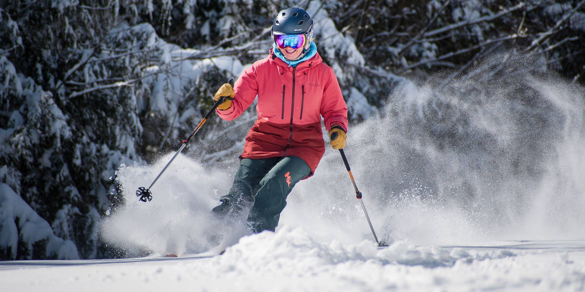 Female skis snowy trees