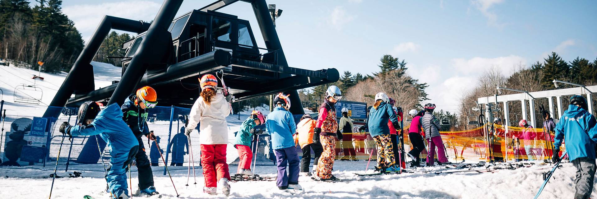 Children put on skis at bottom of chairlift