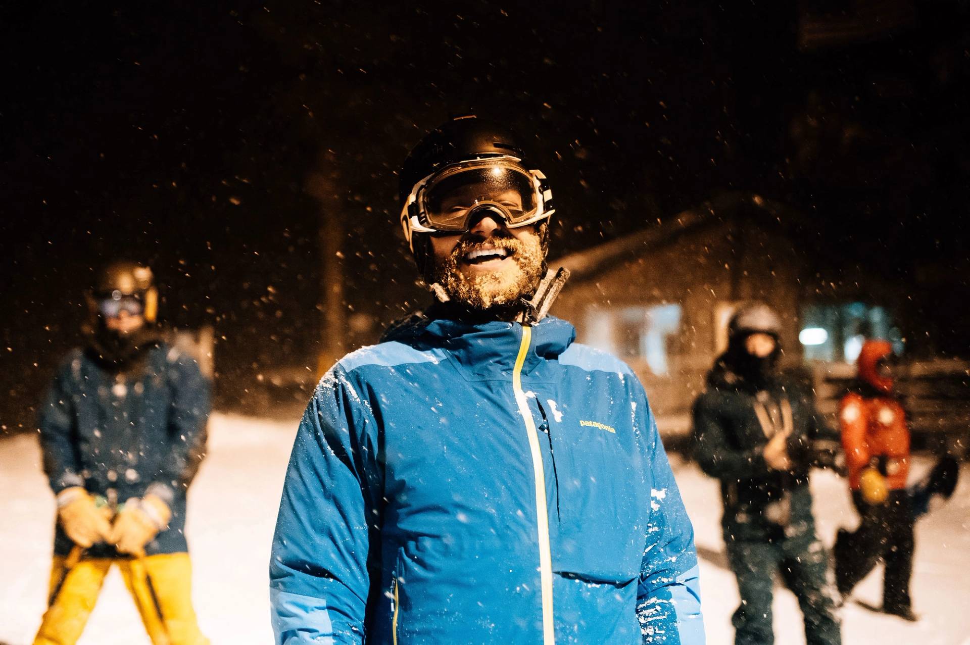 Male skier smiles on a snowy evening