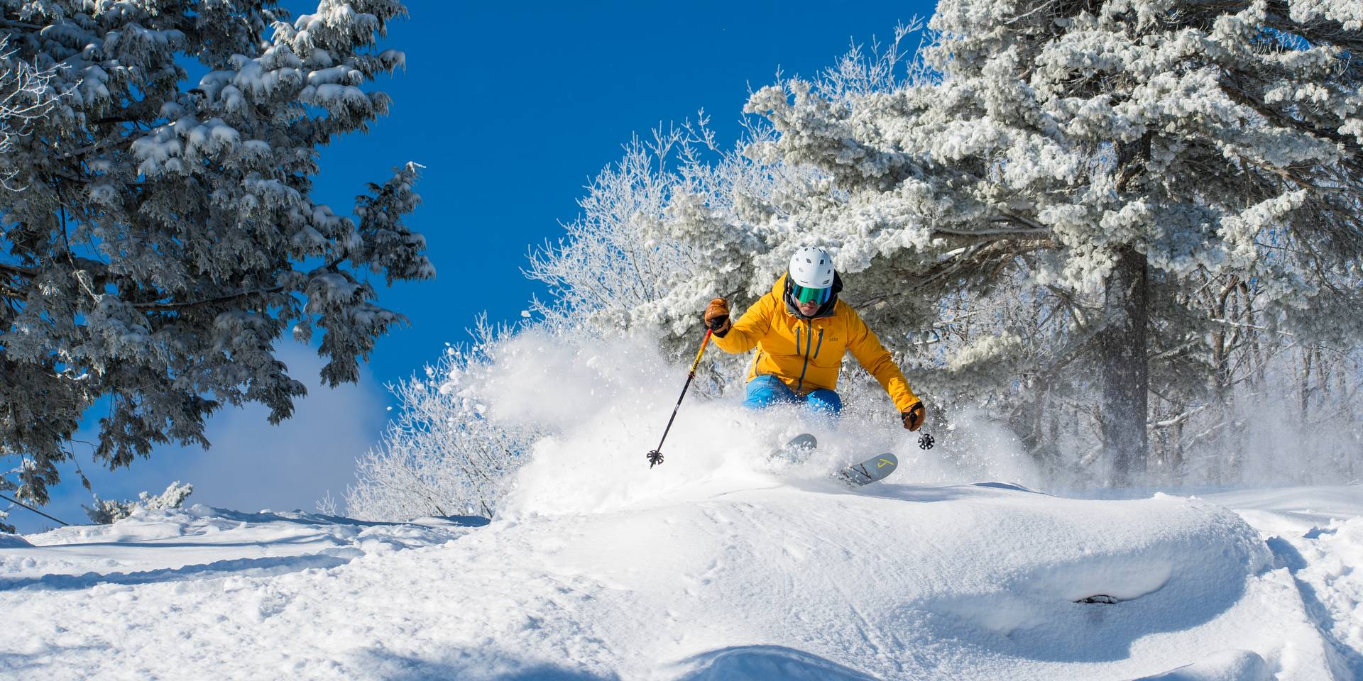 Male skier crusing through upper Kanc