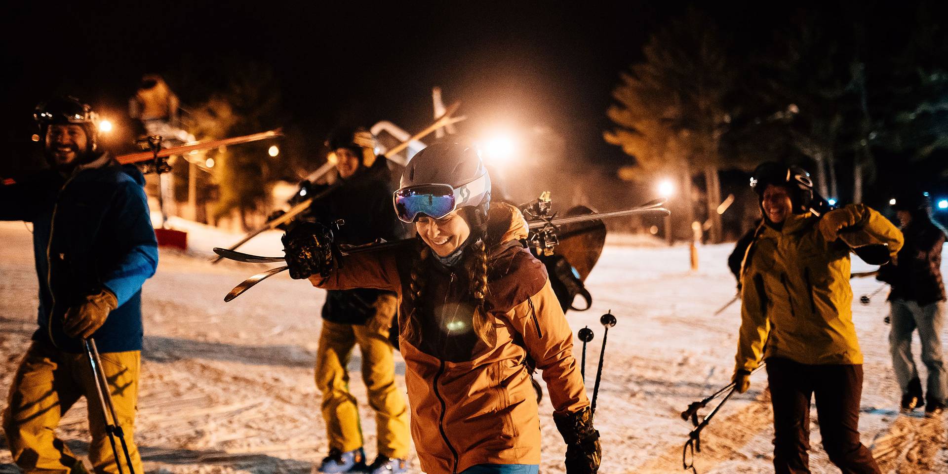 Young group of friends heads out for night skiing