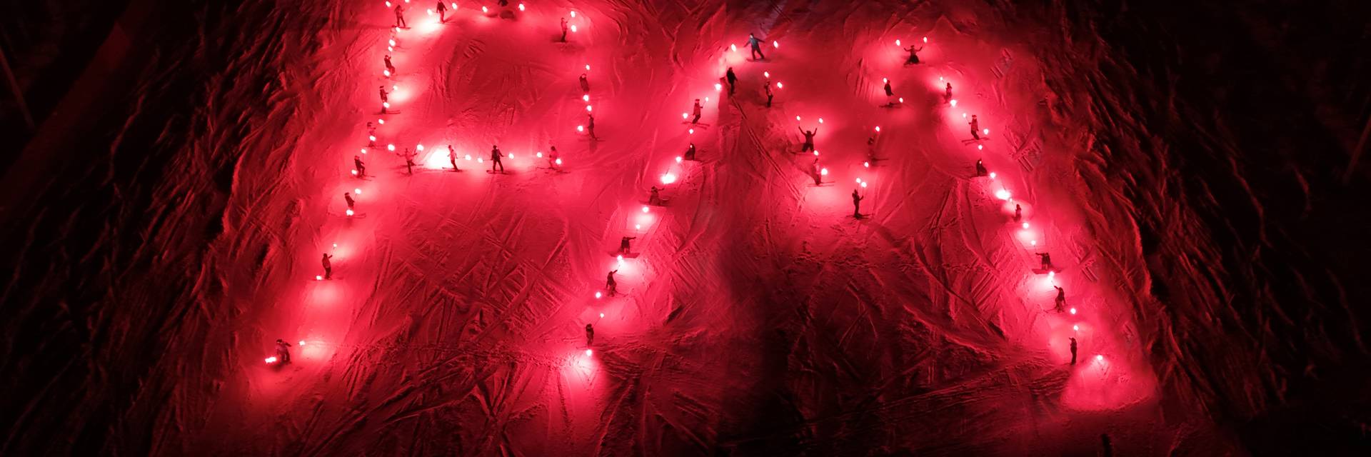 Lights twinkle on Pleasant Mountain across Moose Pond