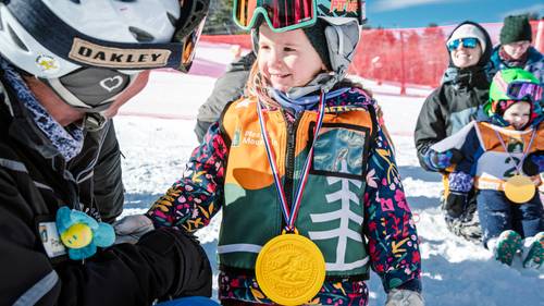 Little girl gets medal from instructor