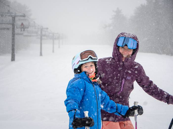 Mum and Daughter standing and smiling in the snow
