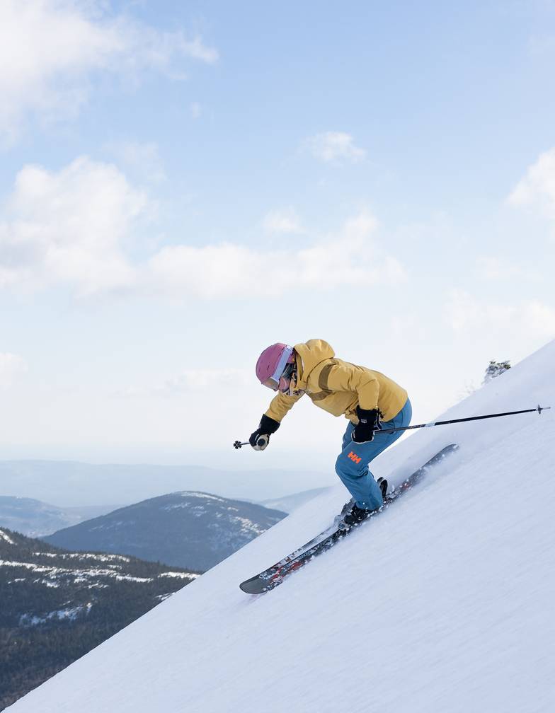 Skier in yellow on steep trail at Sugarloaf