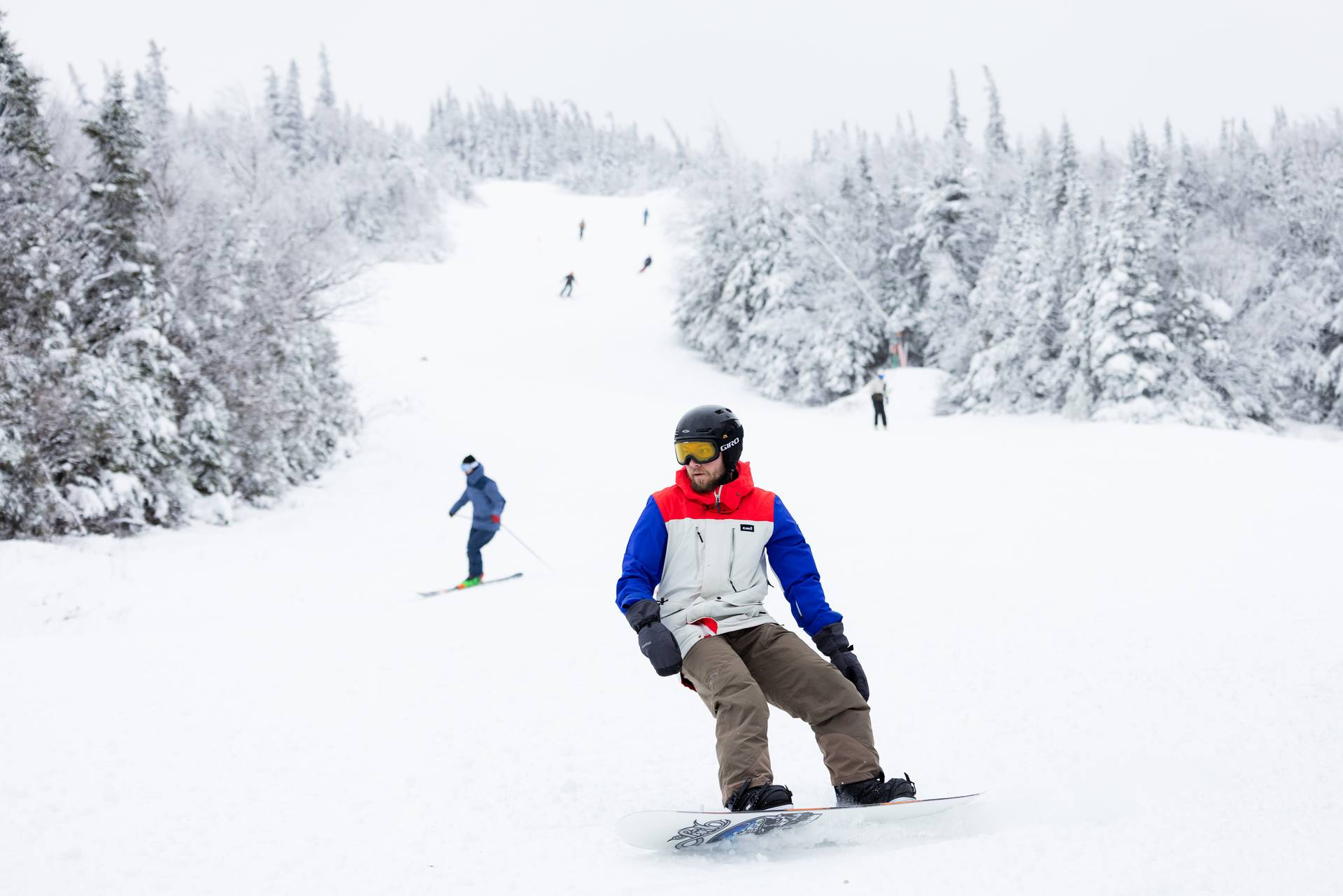 Snowboarder with skiers in background