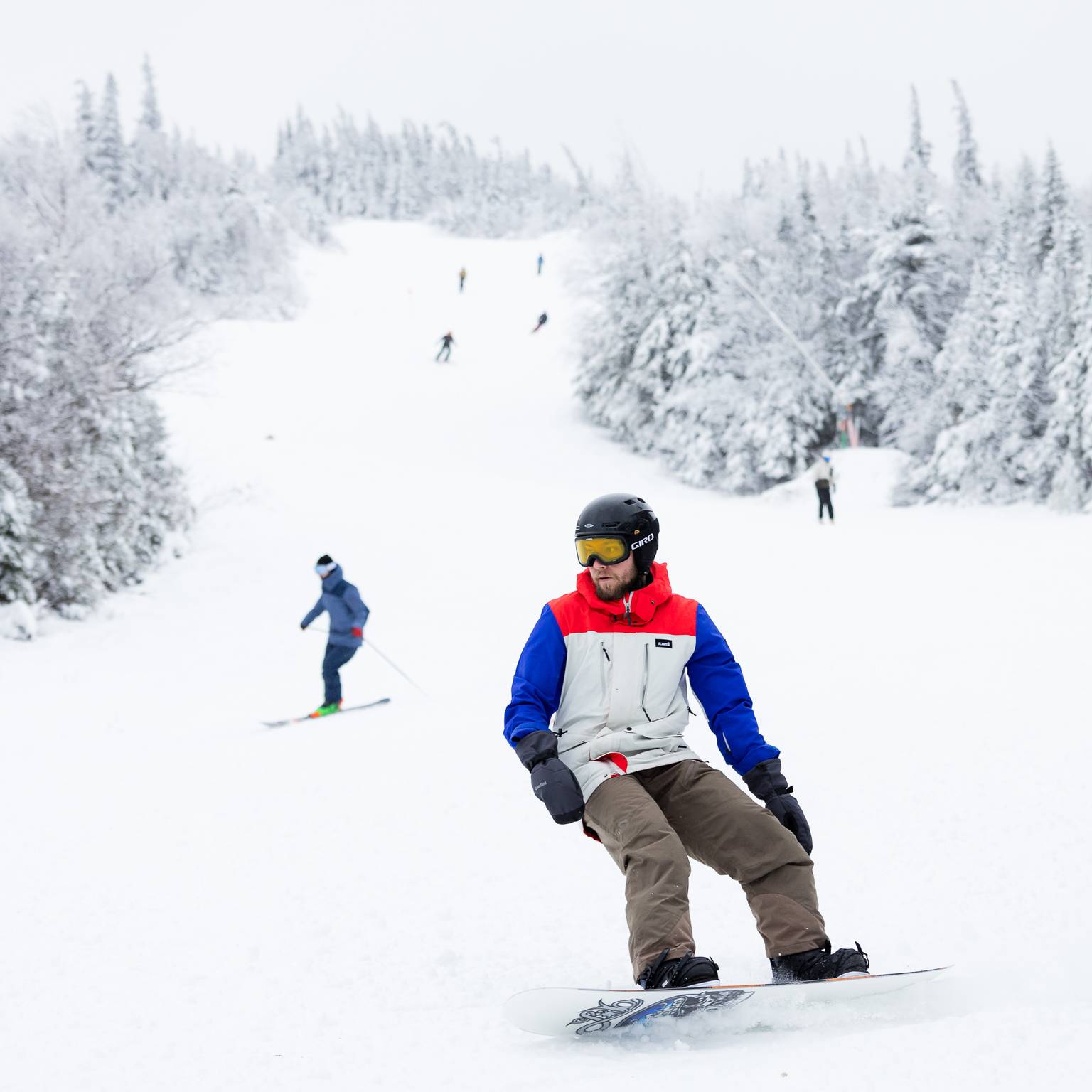 Snowboarder with skiers in background