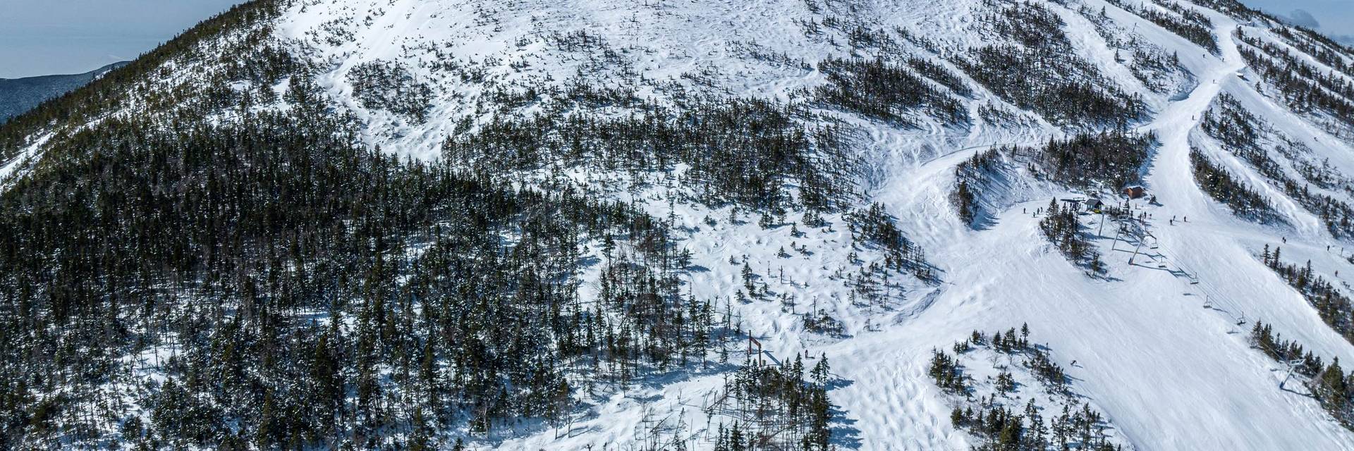 Drone image of the Sugarloaf summit on the east side in winter by Maine Drone Imaging