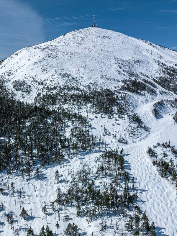 Drone image of the Sugarloaf summit on the east side in winter by Maine Drone Imaging