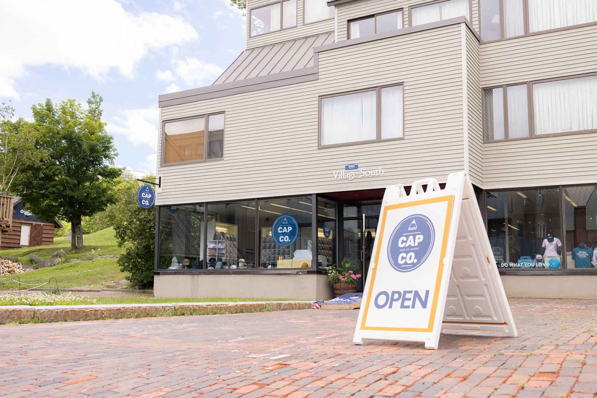 Sugarloaf Cap Co storefront with a sign saying open