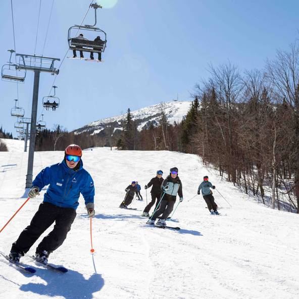 Ski instructor with adult skiers