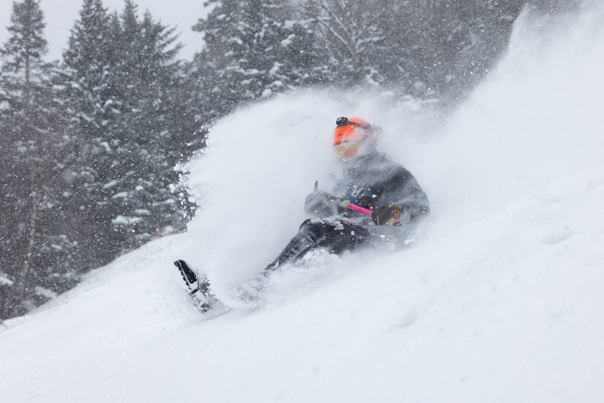 Snowmaker sliding down Spillway on a sled