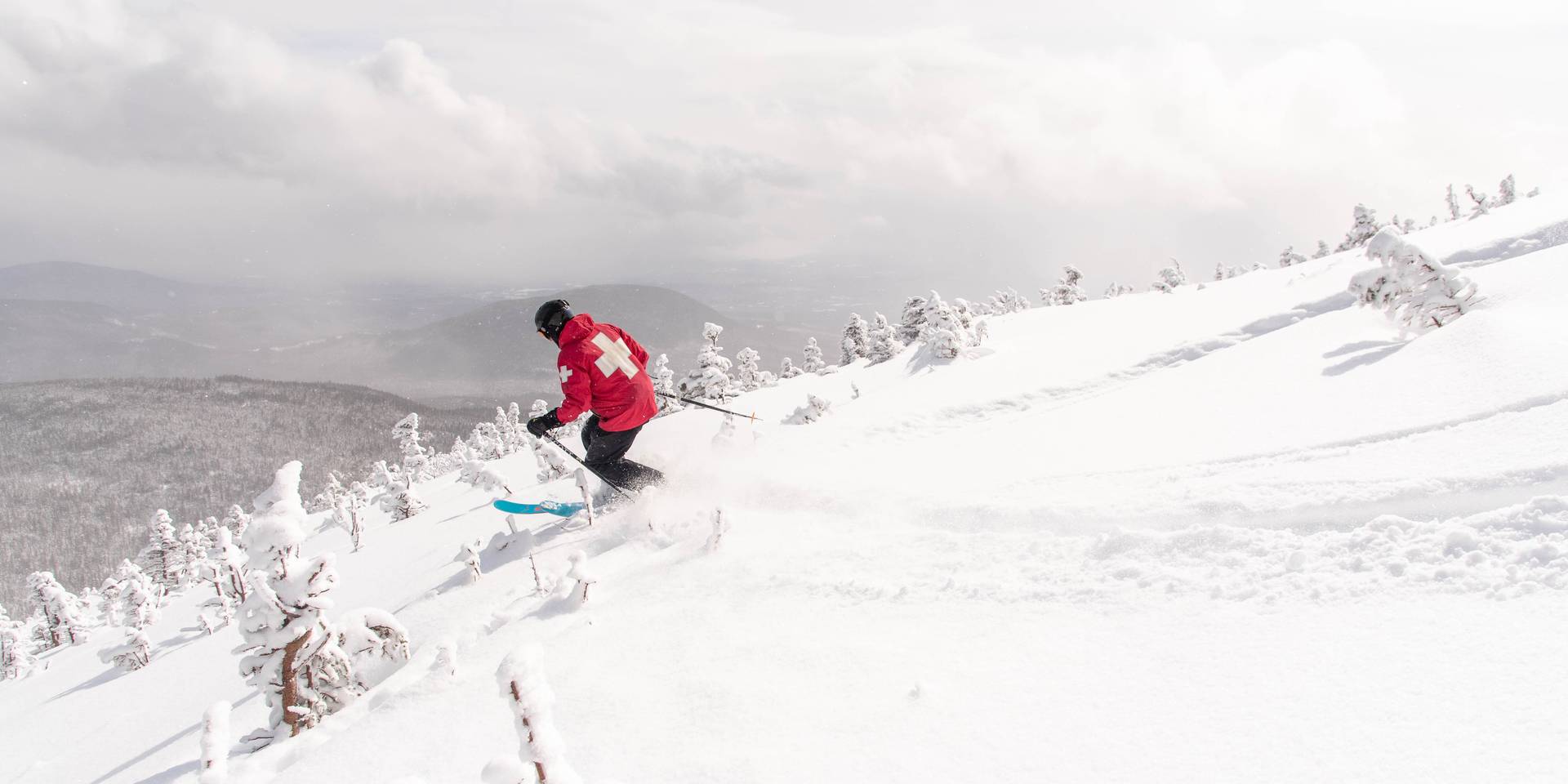 Ski patrol skiing in snowfields