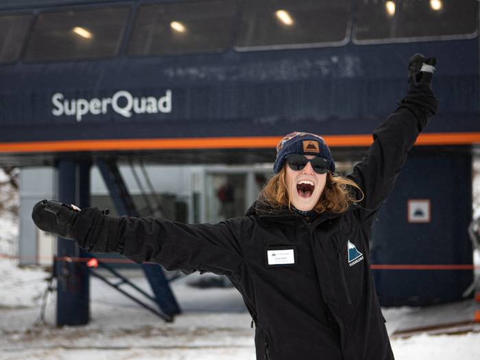 Employee smiling with arms open in the air