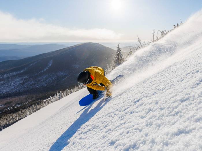 Snowboarder carving up the mountain like it's a holiday bird