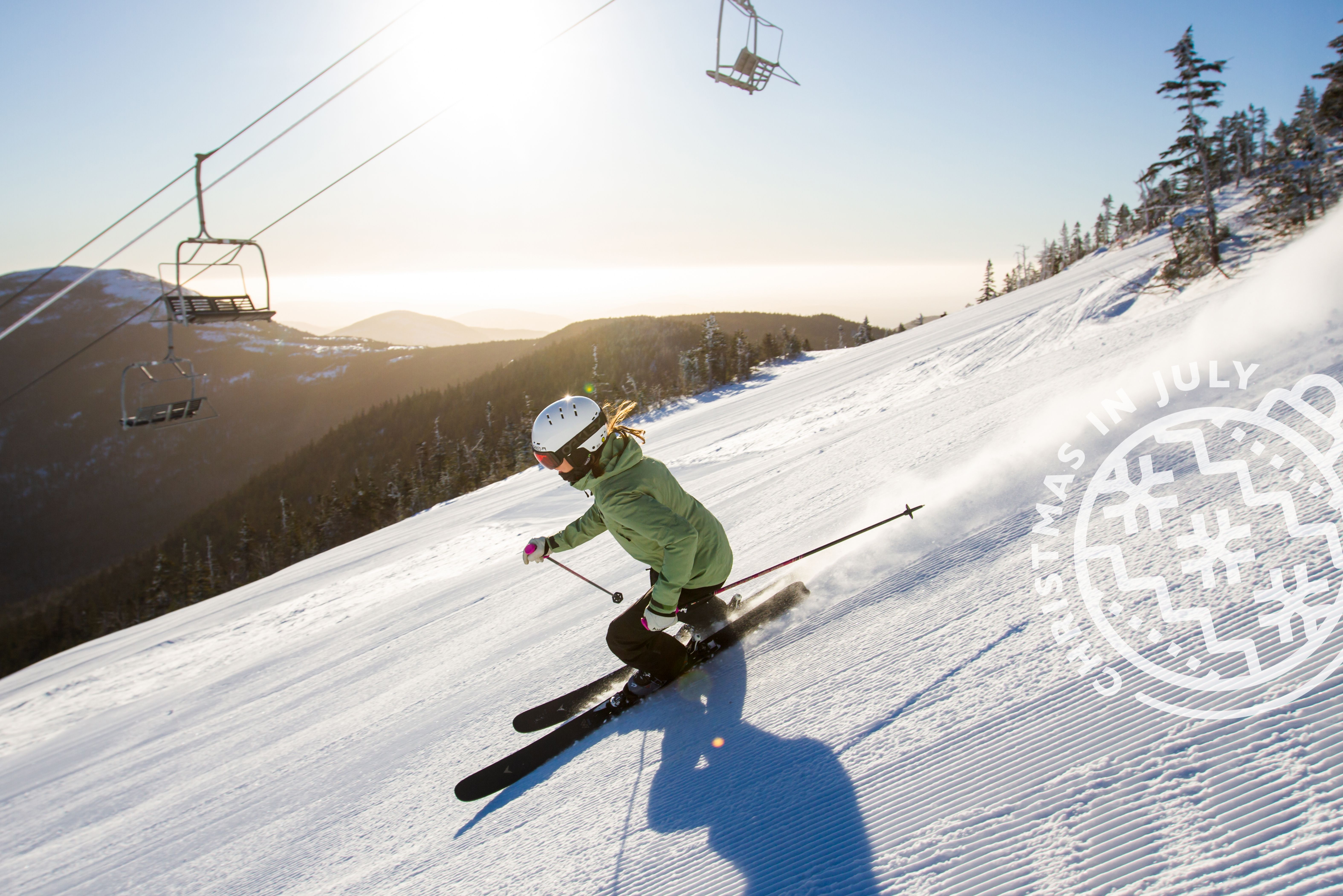 Skier in green with Christmas in July logo