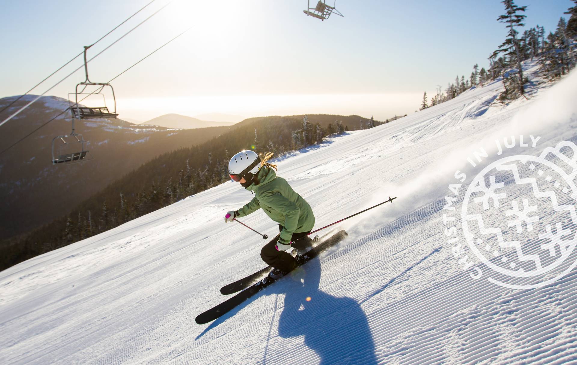 Skier in green with Christmas in July logo