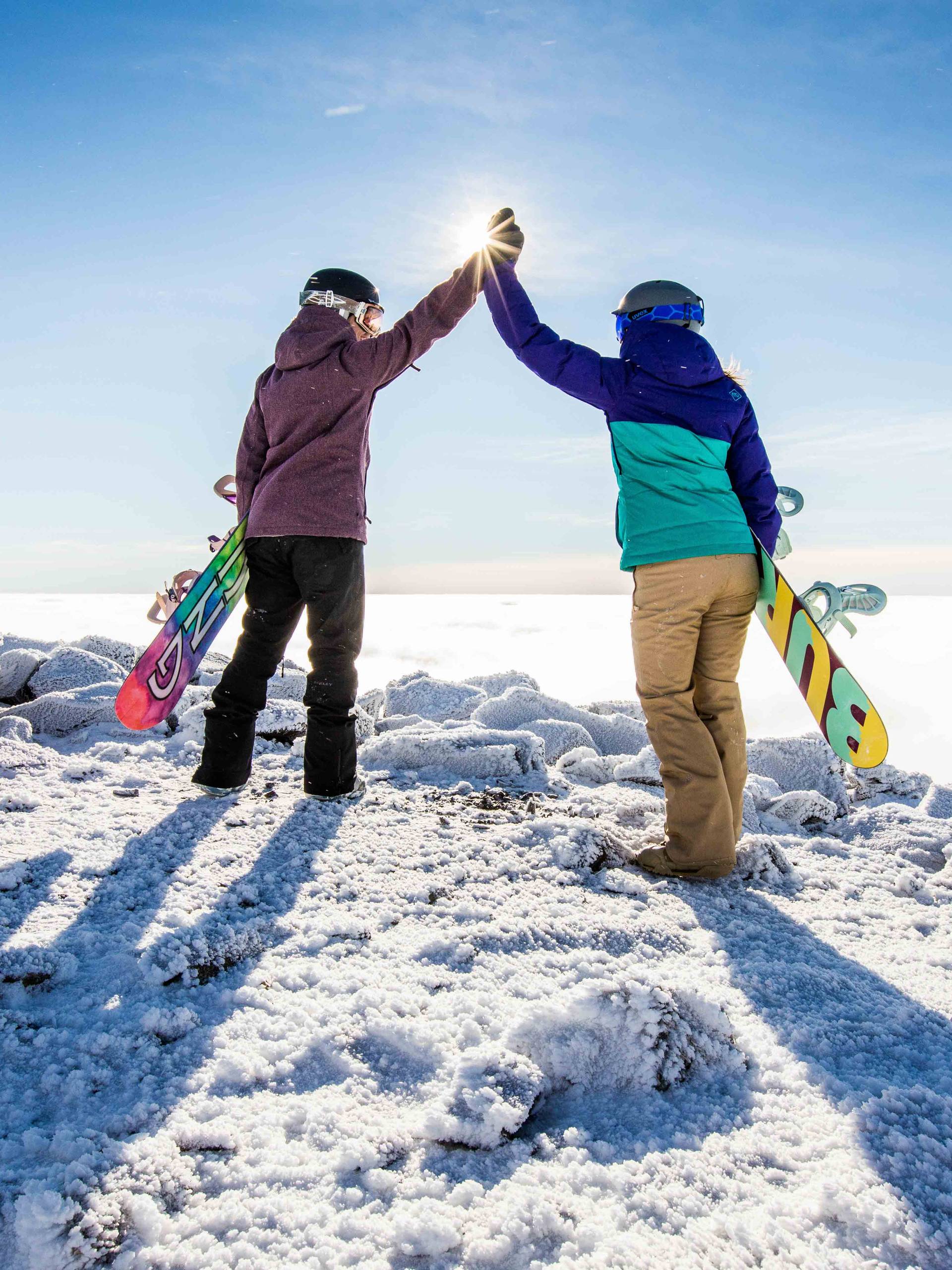 Snowboarders high fiving