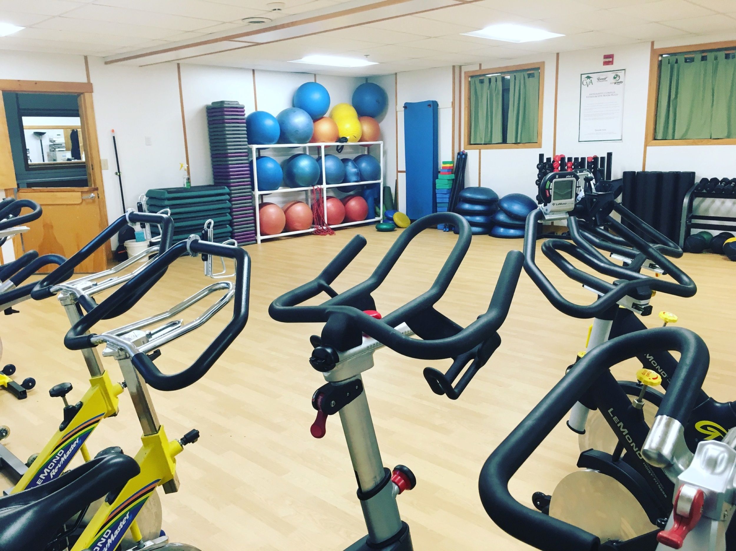 A group exercise room with bikes, balls, and free weights 