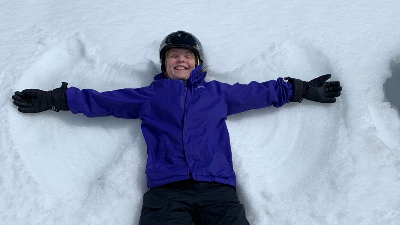 smiling girl making snow angel