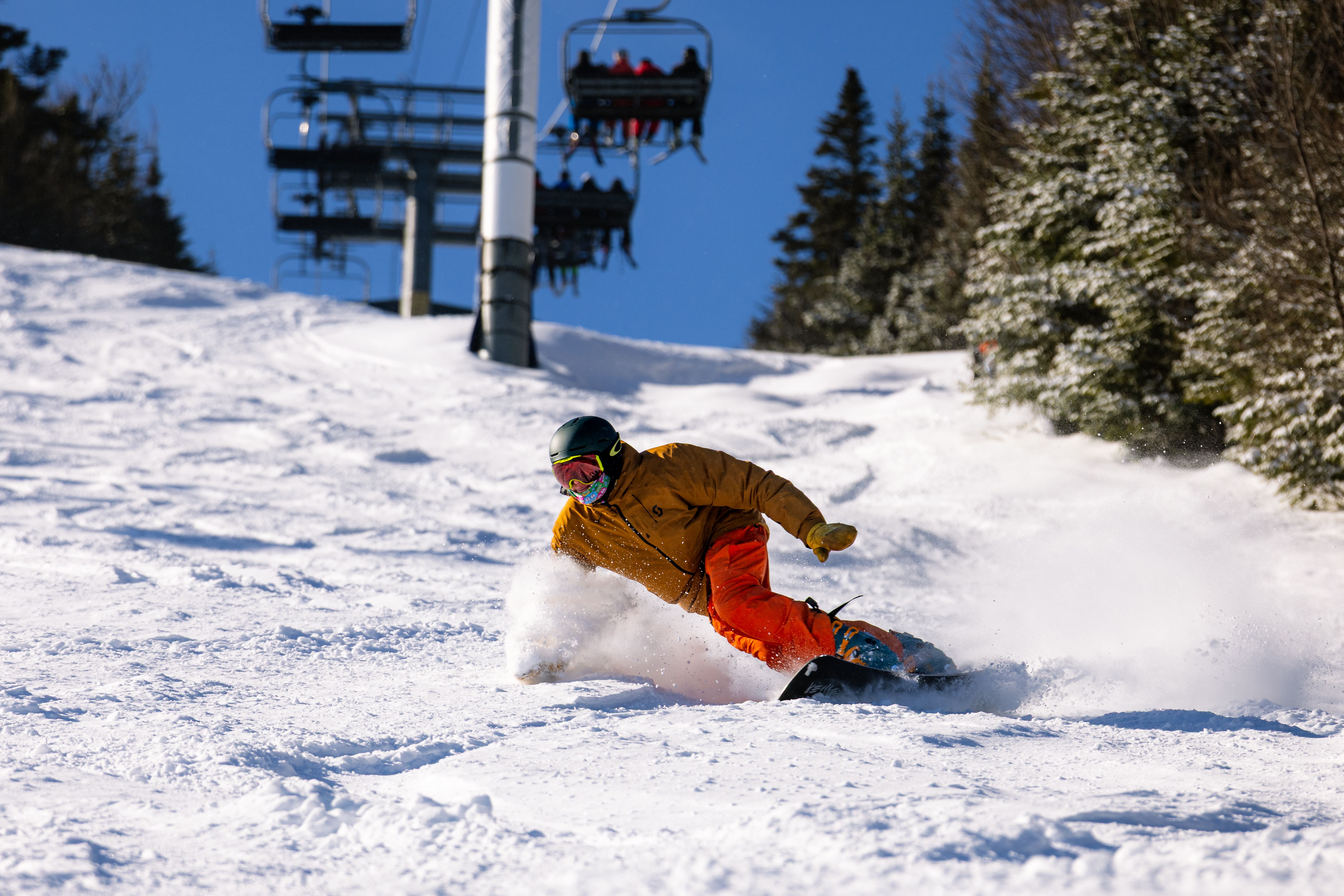 A snowboarder rips through fresh powder