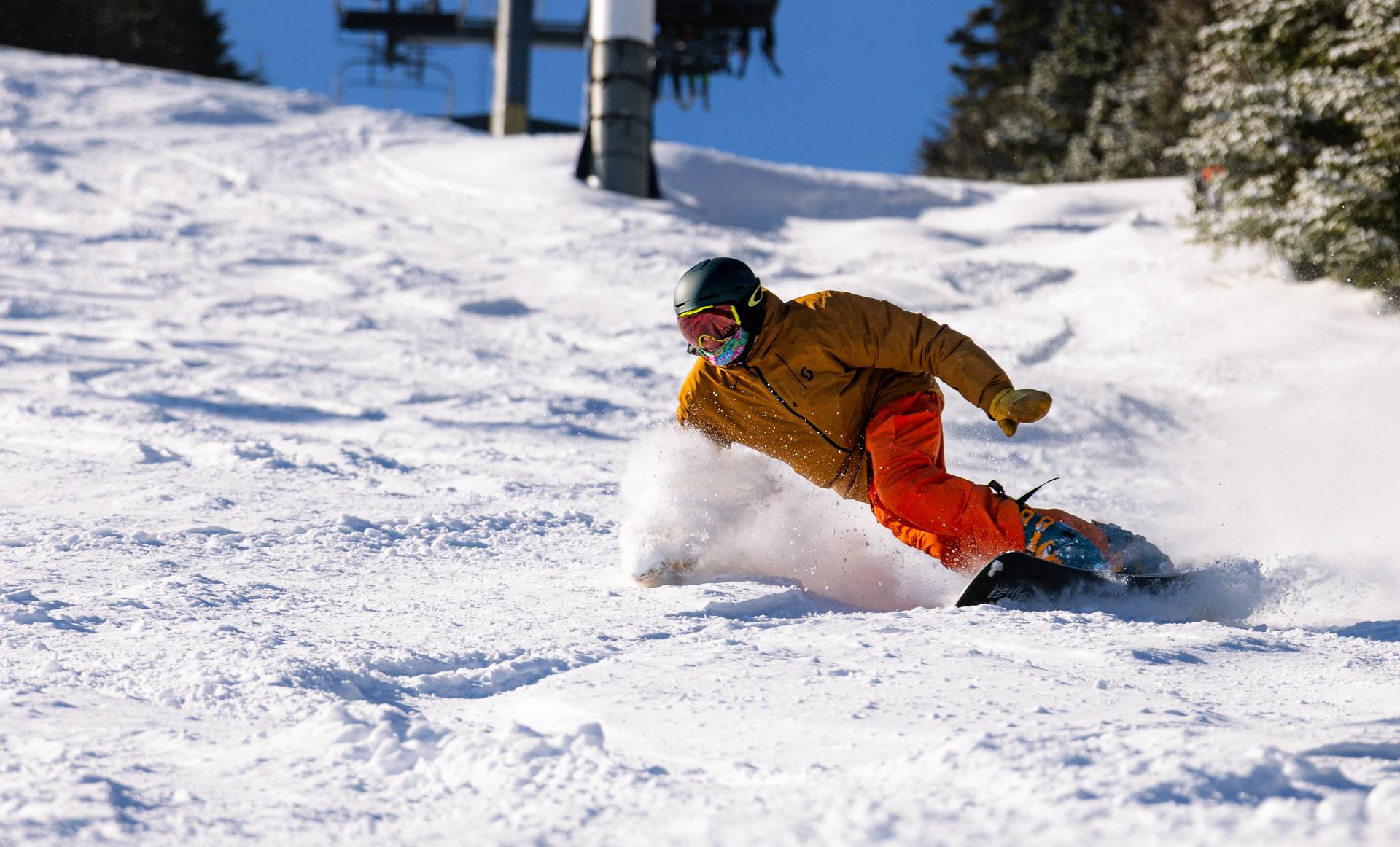 A snowboarder rips through fresh powder
