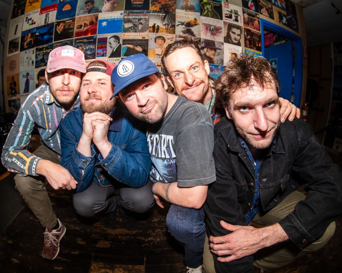 Annie in the Water band posing in front of a poster wall