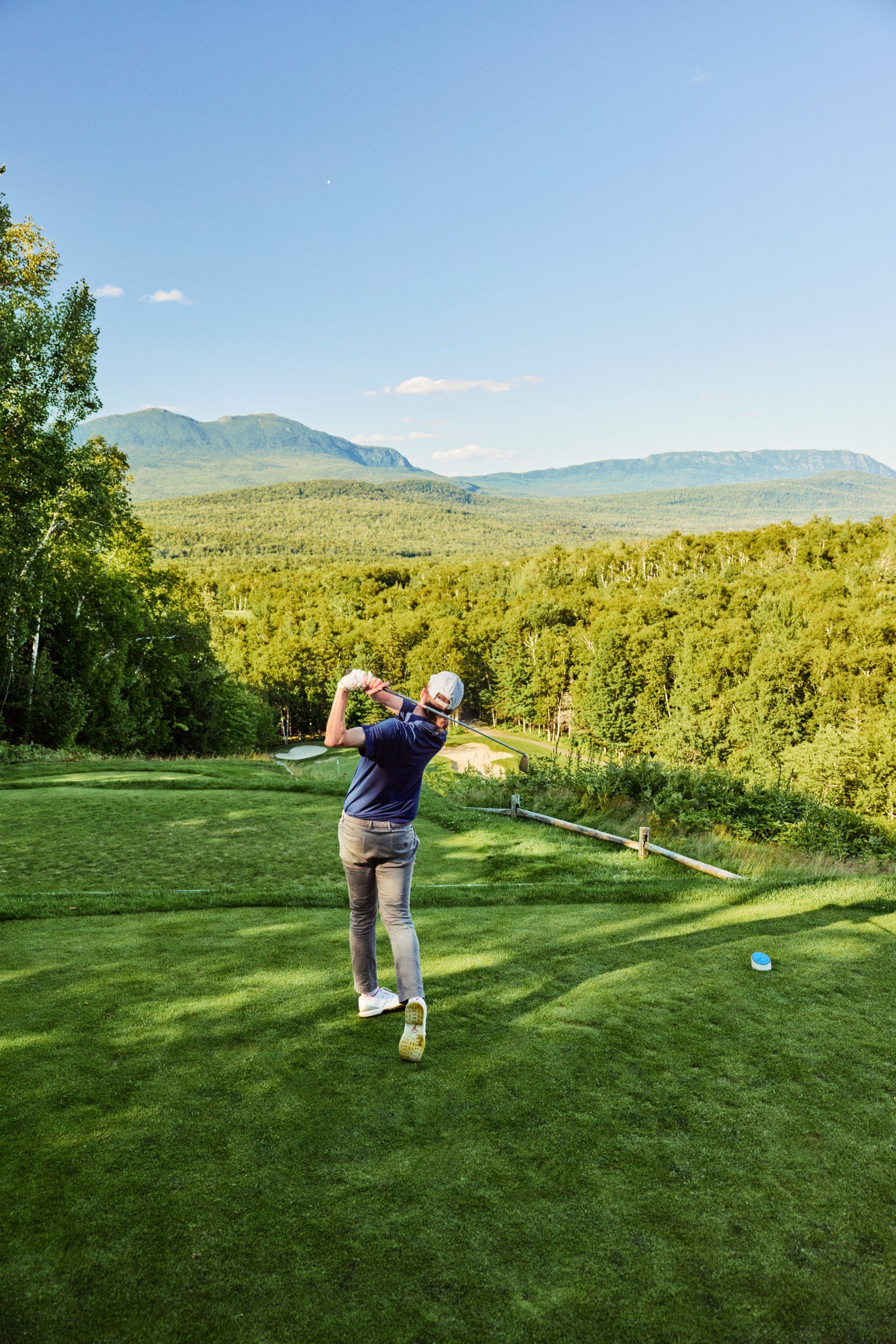 Golfer mid swing at the tee