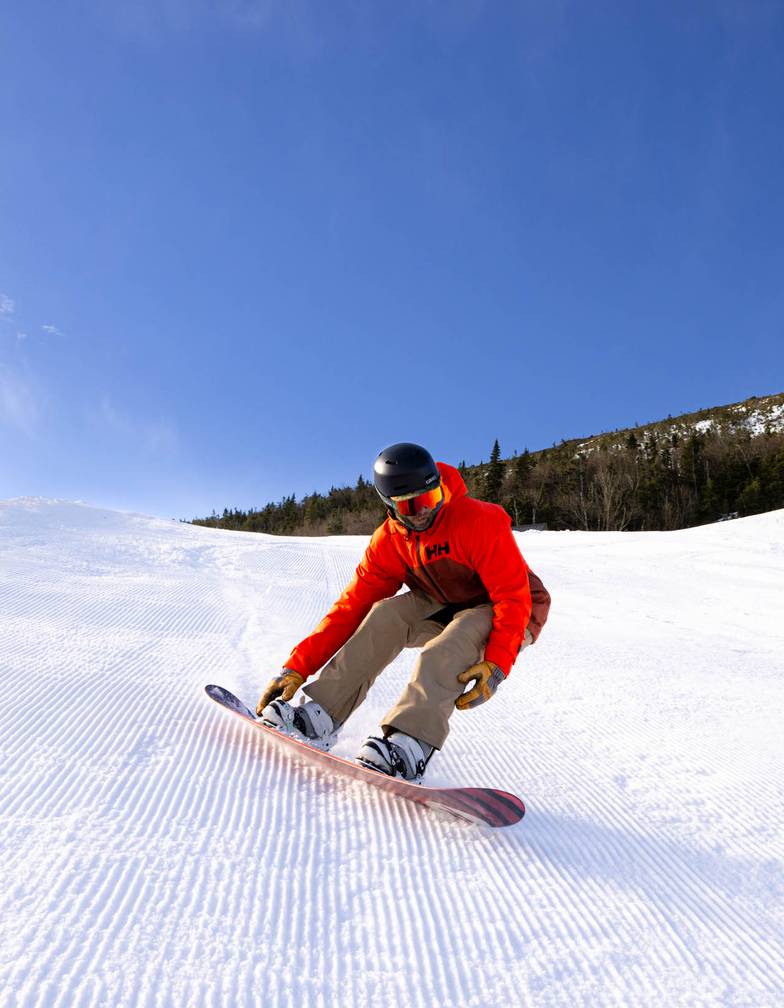 A snowboarded in bright orange