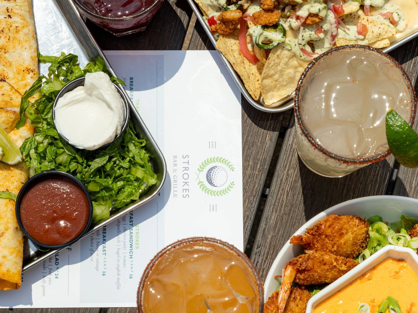 Table on Strokes' patio, set with drinks and three appetizers