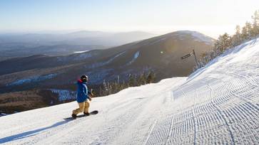Snowboarder riding on a crosscut facing Burnt Mountain