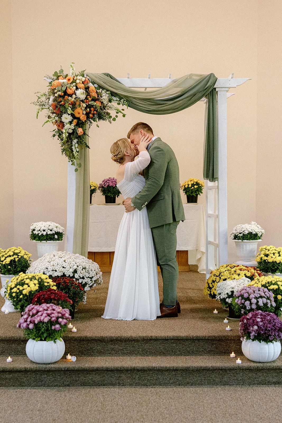 Bride and groom kissing at the alter